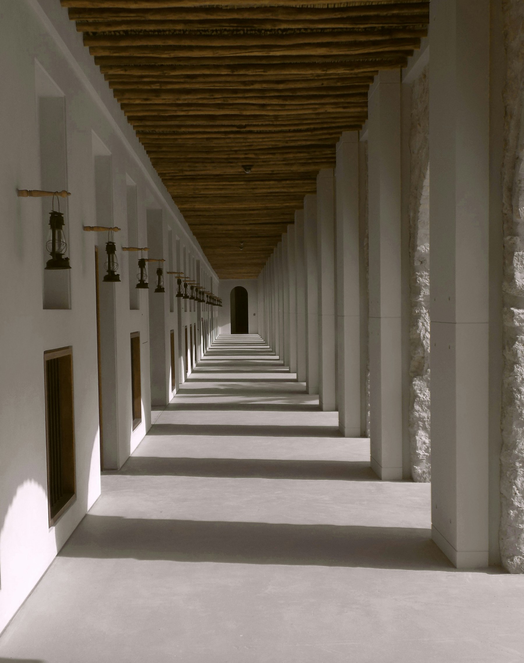 A long, symmetrical concrete corridor lined with columns.