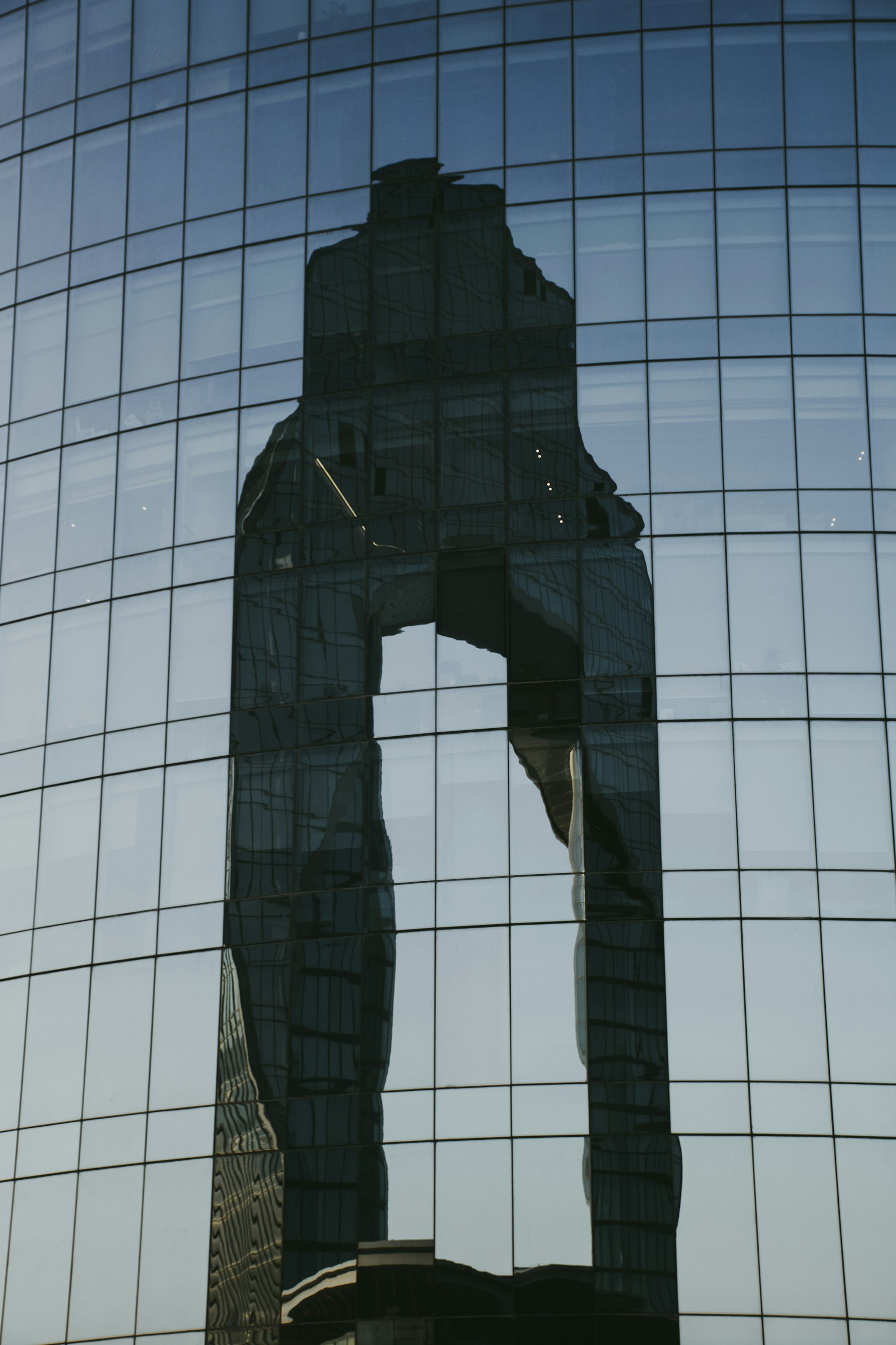 An abstract reflection of a building distorted across a glass facade.